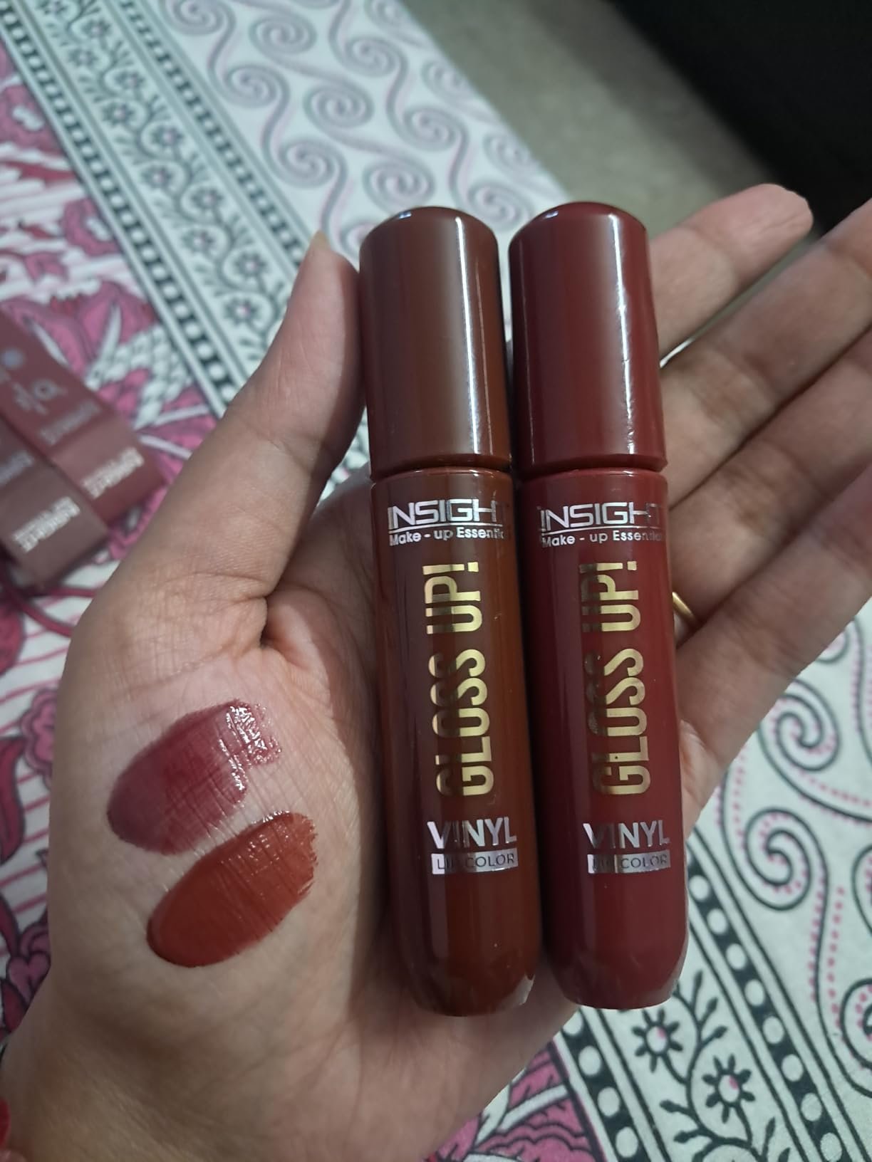 INSIGHT Gloss Up Vinyl Lip Color shades displayed on a hand with glossy swatches, featuring rich pigmentation and high-shine finish.